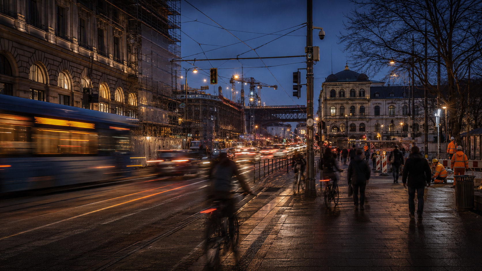 Busy European avenue at dusk with public transport, cyclists, pedestrians and urban roadworks.